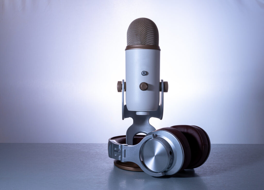 Microphone and headphones for webcast or podcast on light blue background