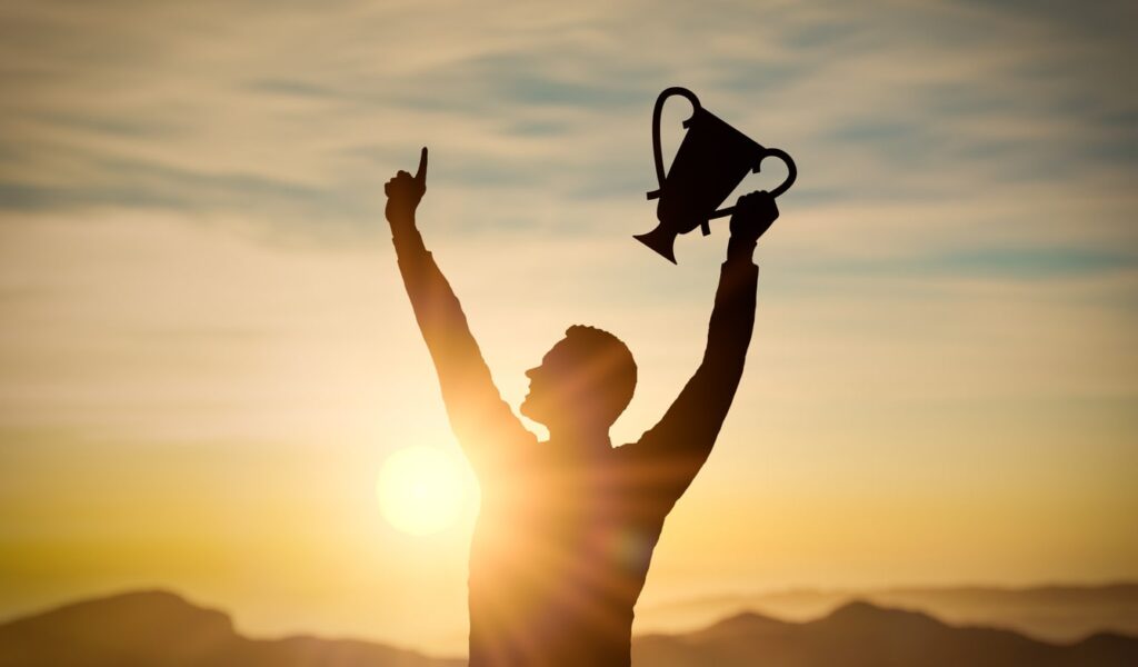 an image of someone holding a trophy signifying winning